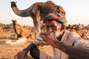 Homme assit de face entrain de boire du lait de chamelle