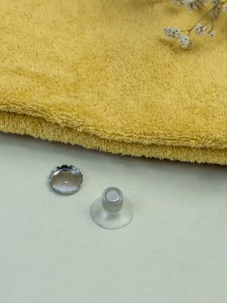 porte-savon aimanté sur une table prêt d'une serviette de couleur jaune