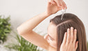 Femme utilisant de l'huile d'argan pour réparer ses cheveux abîmés