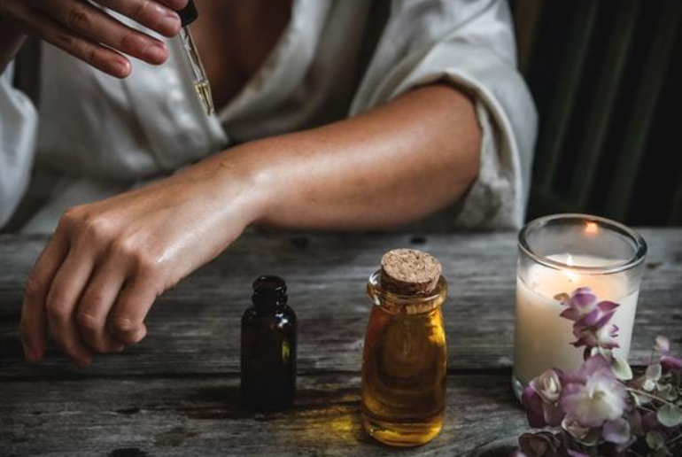 Main mettant de huile d'argan sur le bras