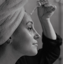 Femme dans salle de bain qui met de l'huile de cacay sur le visage