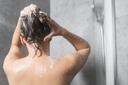 femme de dos se lavant les cheveux 