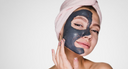 Femme avec du savon noir sur le visage