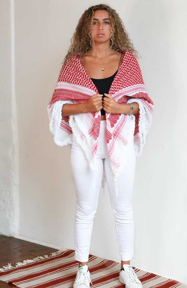 Femme de face portant sur les épaules un keffieh rouge et blanc 