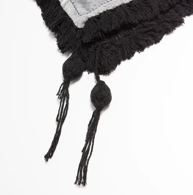 Gros plan sur les pompons d'un keffieh anthracite, mettant en évidence son artisanat.
